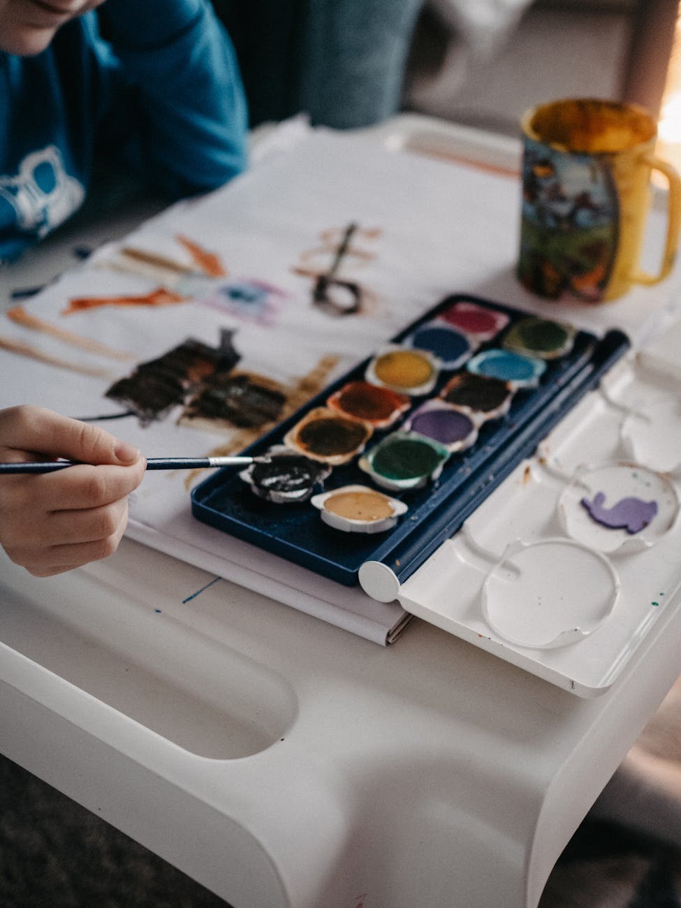 child painting with watercolors indoors